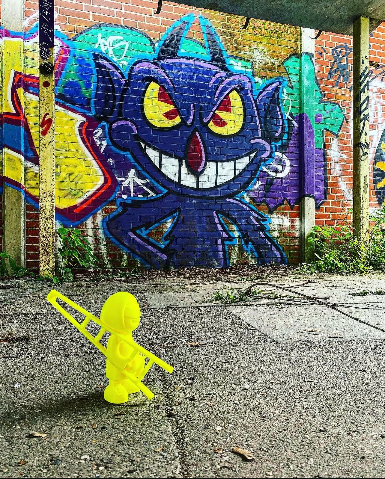 Kleines 3D-Drucker-Männchen vor einer Graffittiwand