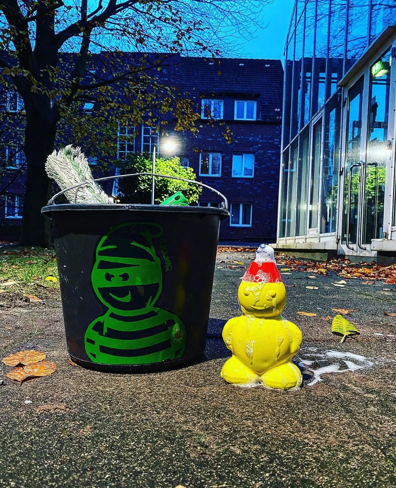 Kleines gelbes Männchen vor einem Putzeimer